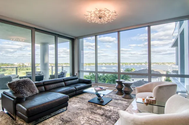 a living room with furniture and floor to ceiling windows