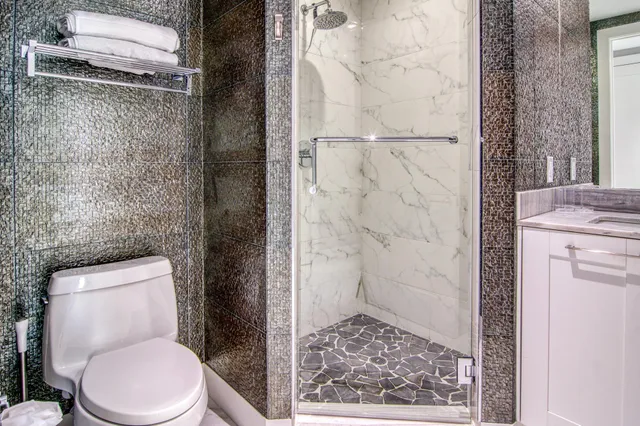 a white toilet sitting next to a shower