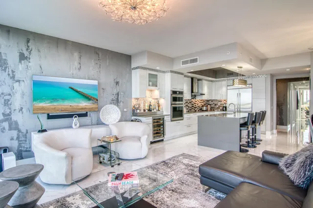 a living room with furniture and a dining table with kitchen view