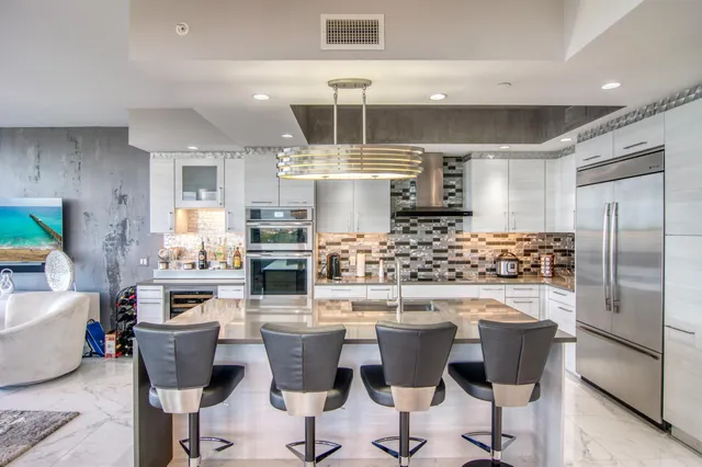 a kitchen with a dining table chairs and refrigerator