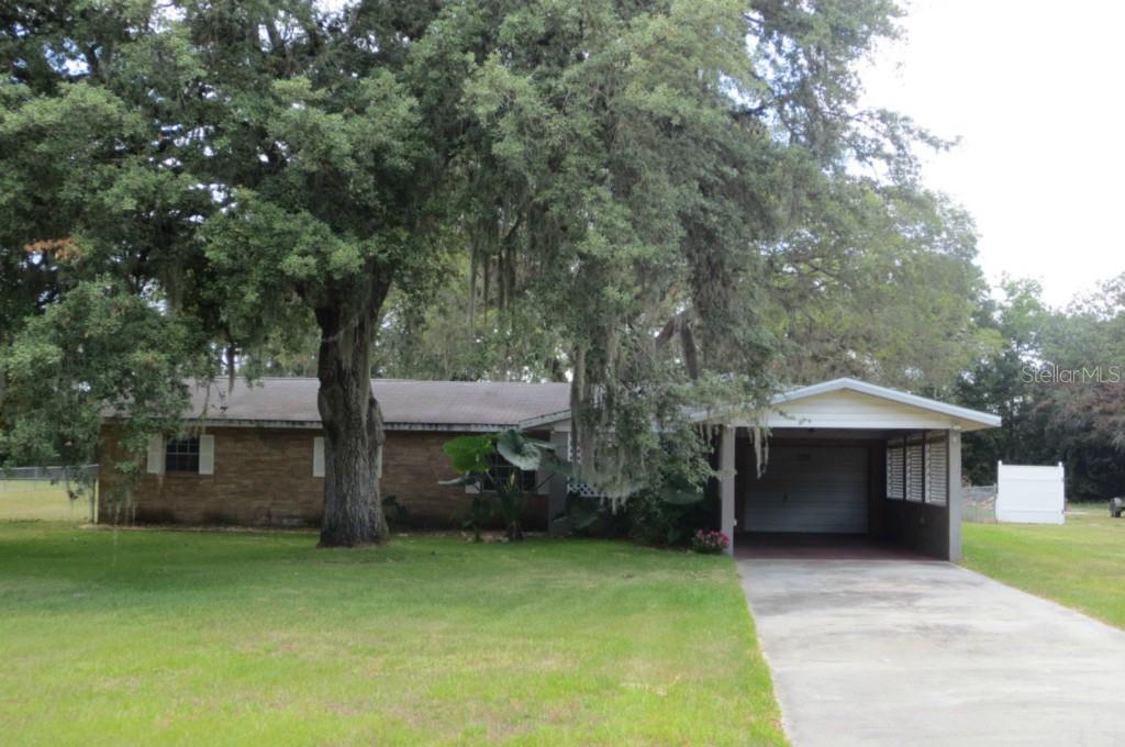 a front view of a house with a garden and trees