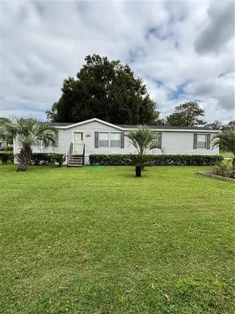 a white house with yard in front of it