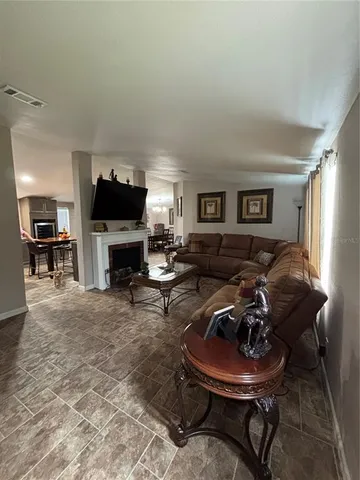 a living room with furniture a large window and a fireplace