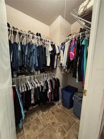 a view of walk in closet with clothes and shoes