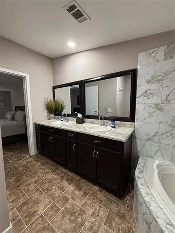 a spacious bathroom with a double vanity sink and a mirror