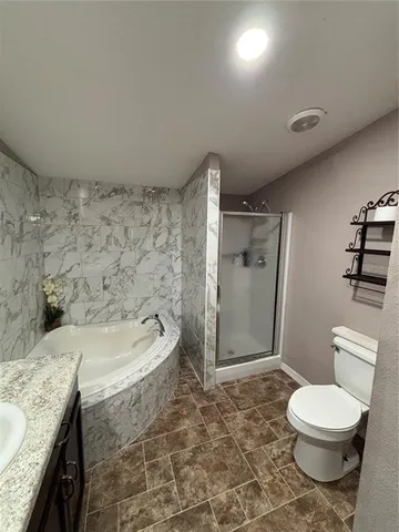 a bathroom with a granite countertop sink toilet and shower