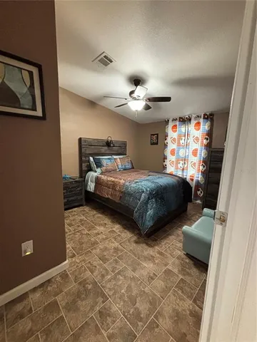 a bedroom with a bed and a tv on wall