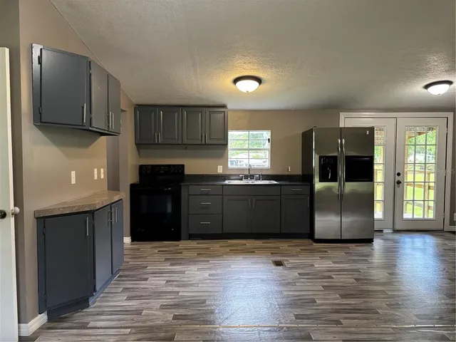 a kitchen with granite countertop a refrigerator and a sink