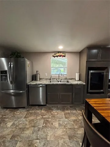a kitchen with stainless steel appliances granite countertop a stove a sink and a refrigerator