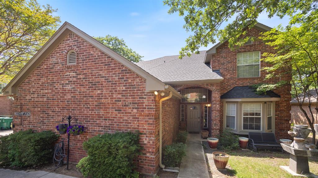 1508 Valley Creek Road Denton, TX 76205 - Photo 2 of 33 a view of a brick house with large windows and a table and chairs