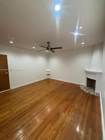 an empty room with wooden floor and fireplace