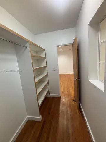 a view of walk in closet with wooden floor and closet