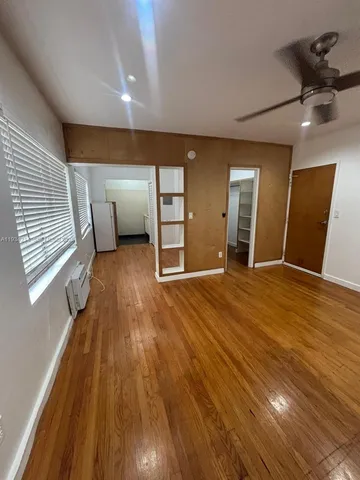 a view of a livingroom with wooden floor and a ceiling fan