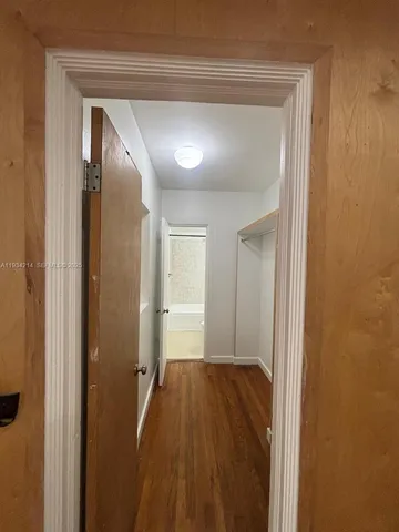 a view of a room with wooden floor and a bathroom