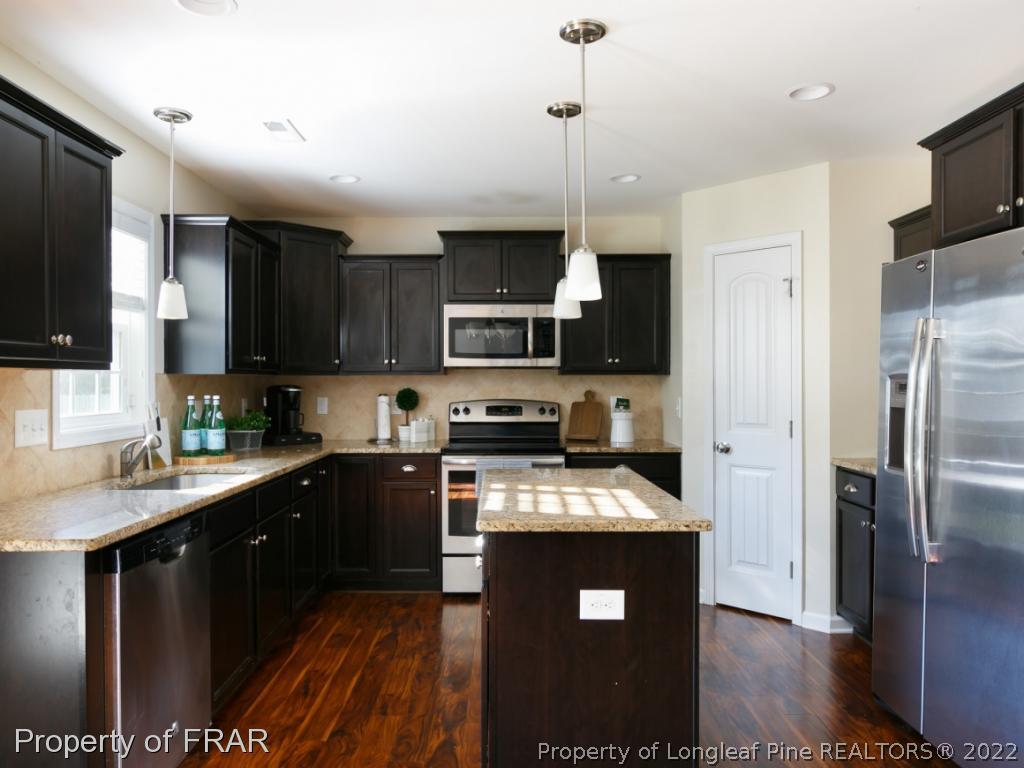 534 Townsend Road Raeford, NC 28376 - Photo 12 of 35 a kitchen with stainless steel appliances granite countertop a refrigerator a stove a sink a microwave and wooden cabinets
