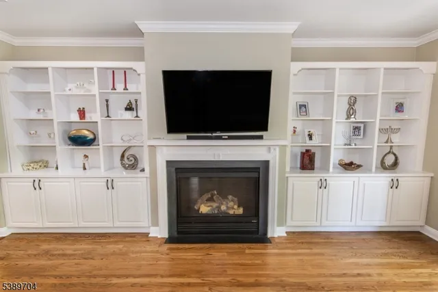 a living room with a fireplace a flat screen tv and a bookshelf