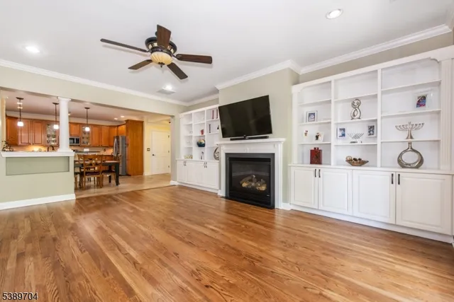 wooden floor in an empty room with a fireplace and a window