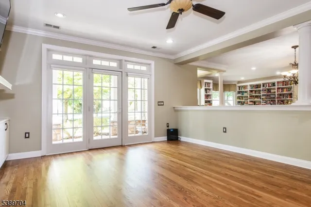 a view of an empty room with window and wooden floor