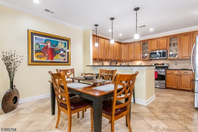 a dining area with a table chairs and a kitchen view