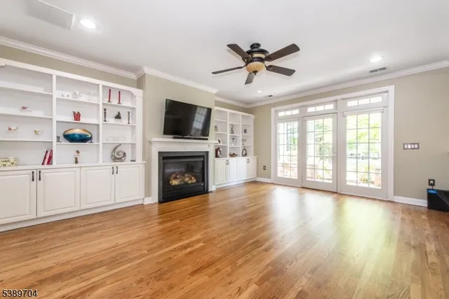 a view of a livingroom with wooden floor and a ceiling fan
