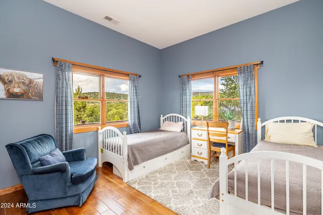 a bedroom with a balcony a bed and wooden floor