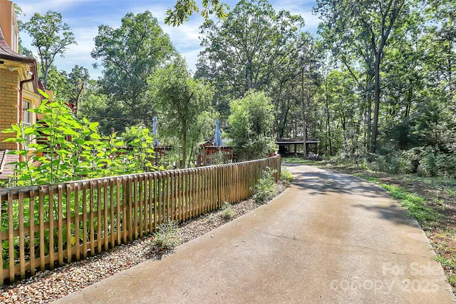 a view of a pathway with a wrought fence