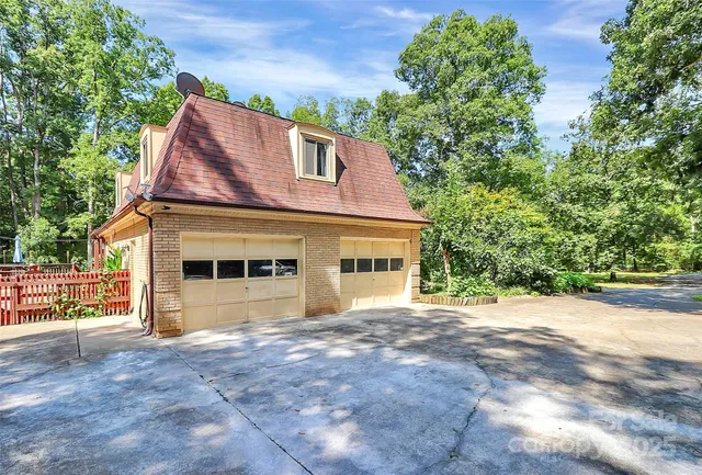 a view of a house with a yard and large tree