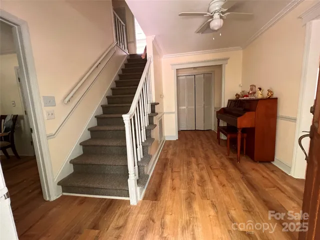 a view of a hallway with wooden floor and staircase