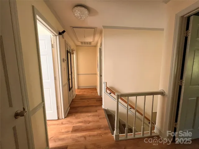 a view of a hallway with wooden floor and staircase
