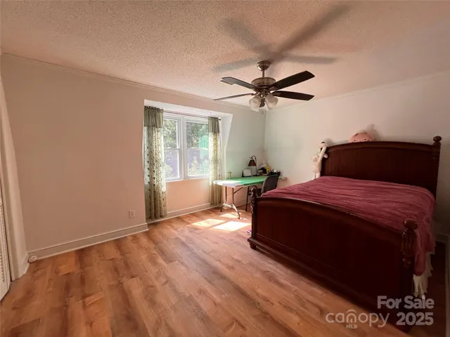 a bedroom with a bed ceiling fan and a window
