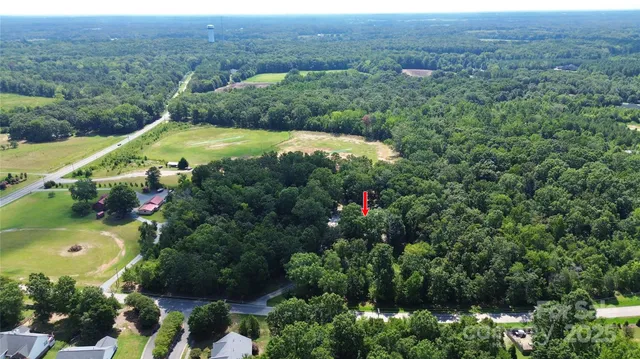 an aerial view of a house with a yard and lake view