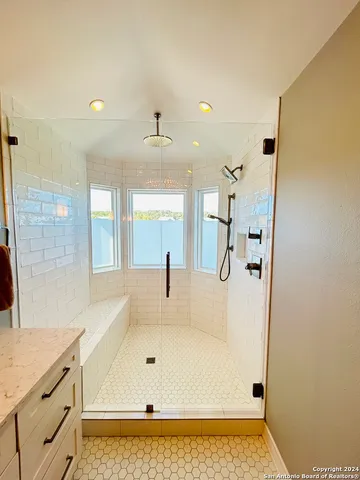 a bathroom with a tub sink and mirror