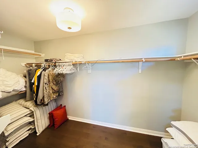 a view of walk in closet with clothes and shoes
