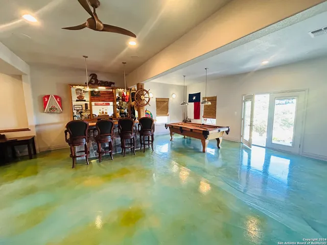 a living room with furniture and a pool table