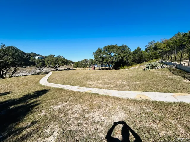 a view of yard with swimming pool and trees in the background
