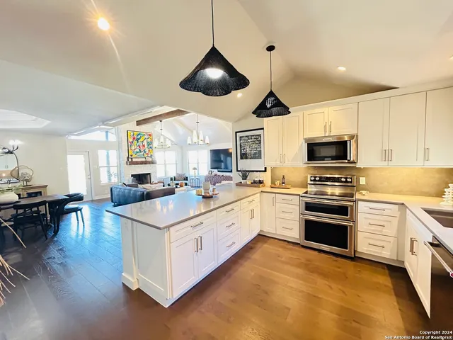 a kitchen with a stove cabinets and a wooden floor