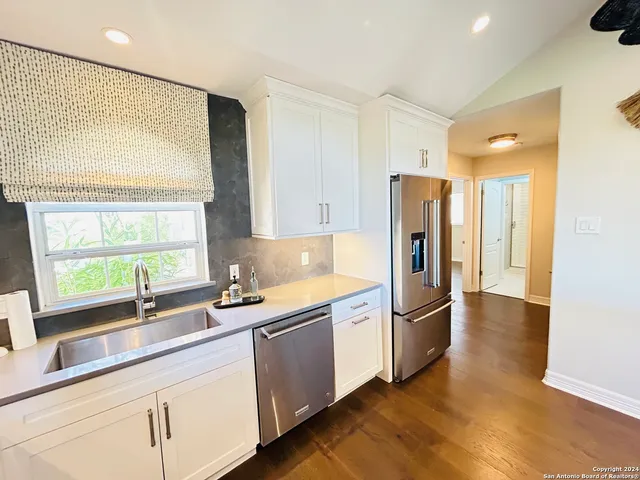 a kitchen with stainless steel appliances granite countertop a refrigerator and a sink