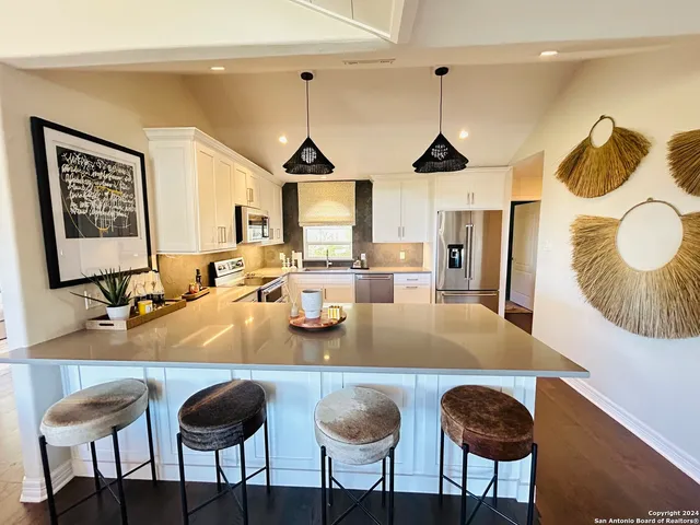 a dining room with granite countertop a table chairs and a chandelier