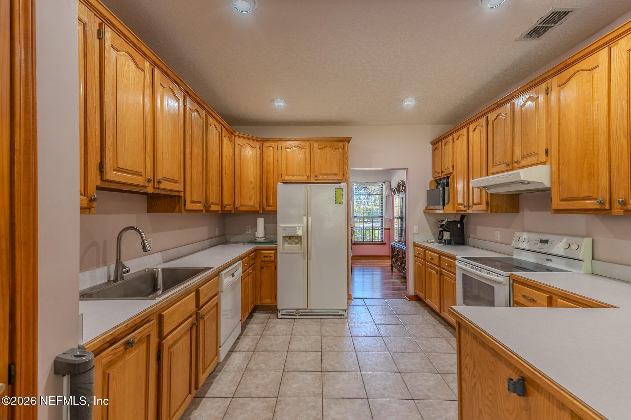 1801 Lake Road Jacksonville, FL 32226 - Photo 58 of 72 a kitchen with stainless steel appliances granite countertop a refrigerator a sink dishwasher a stove top oven and a dining table with wooden floor