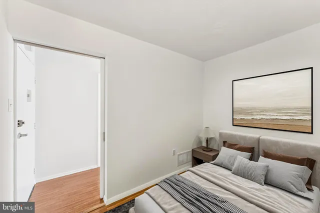 a bedroom with a bed and a painting on the wall