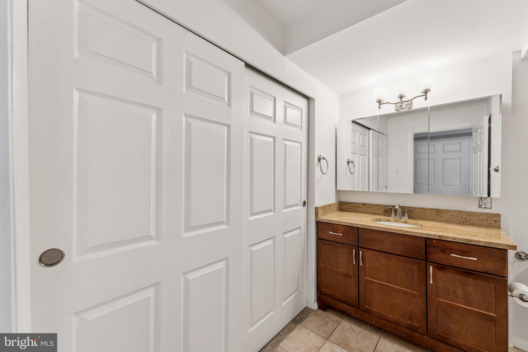 1440 N Street Northwest, Unit 312 Washington, DC 20005 - Photo 17 of 31 a spacious bathroom with a granite countertop sink and a mirror