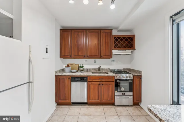 a kitchen with stainless steel appliances granite countertop a stove a refrigerator and a sink