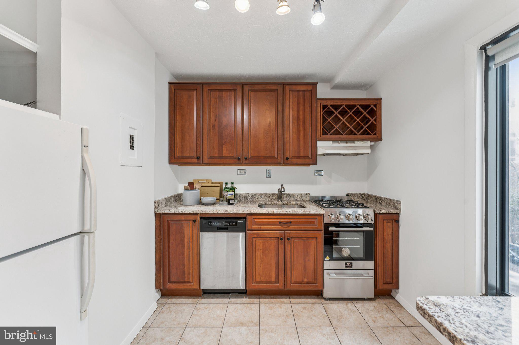 1440 N Street Northwest, Unit 312 Washington, DC 20005 - Photo 8 of 31 a kitchen with stainless steel appliances granite countertop a stove a refrigerator and a sink