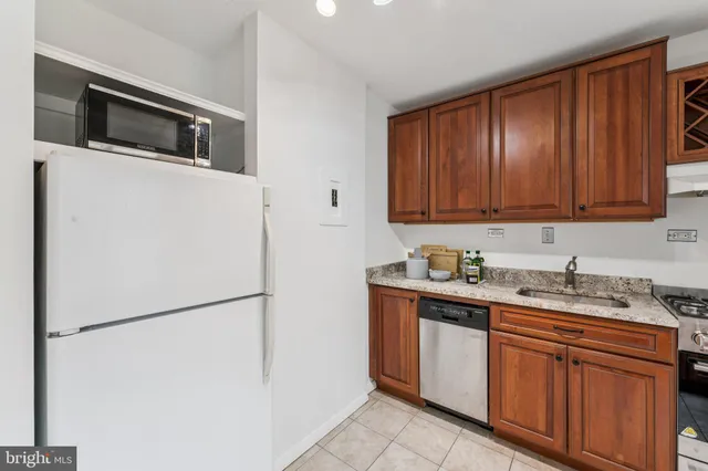 a kitchen with stainless steel appliances granite countertop a refrigerator a stove a sink and dishwasher