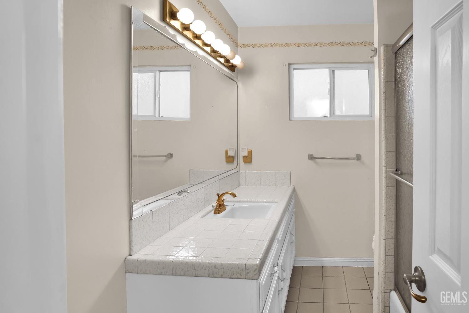 Undisclosed Address Bakersfield, CA 93312 - Photo 16 of 26 a bathroom with a sink and a mirror