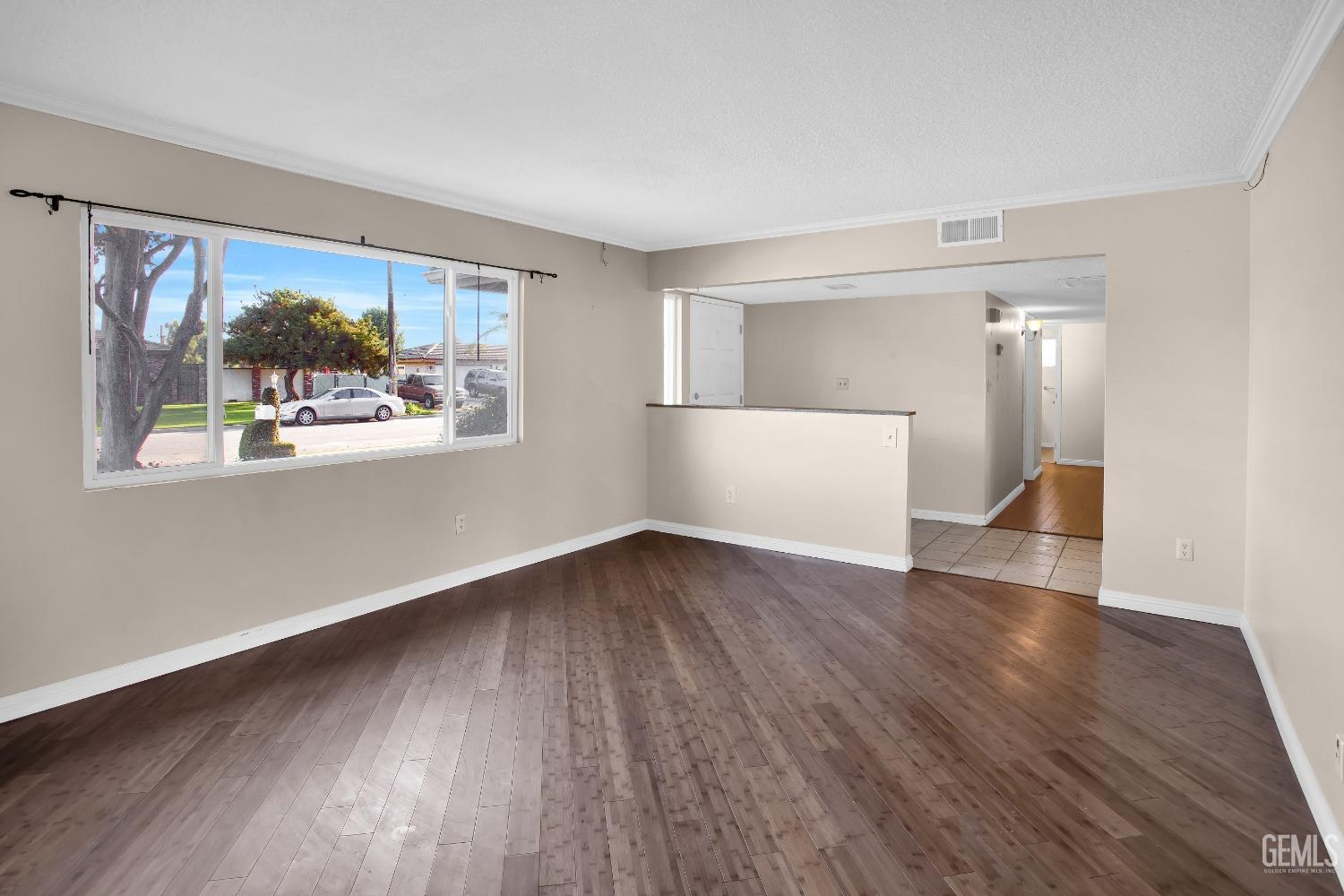 Undisclosed Address Bakersfield, CA 93312 - Photo 4 of 26 an empty room with wooden floor and windows