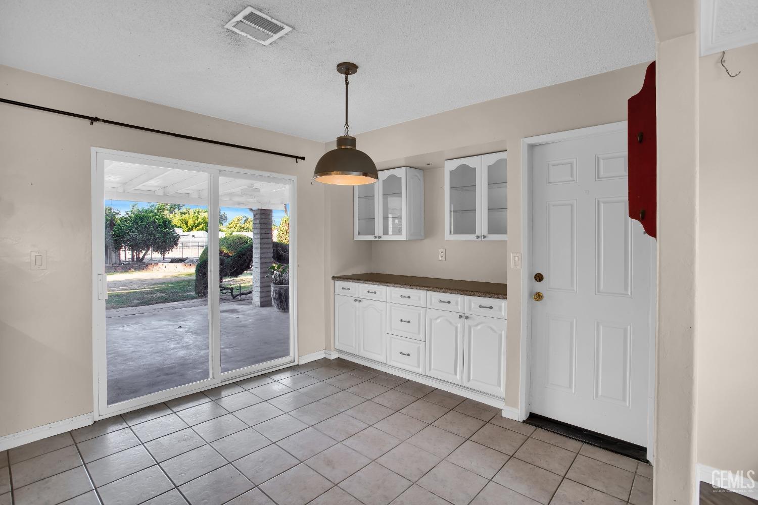 Undisclosed Address Bakersfield, CA 93312 - Photo 5 of 26 a open kitchen with white cabinets and a chandelier