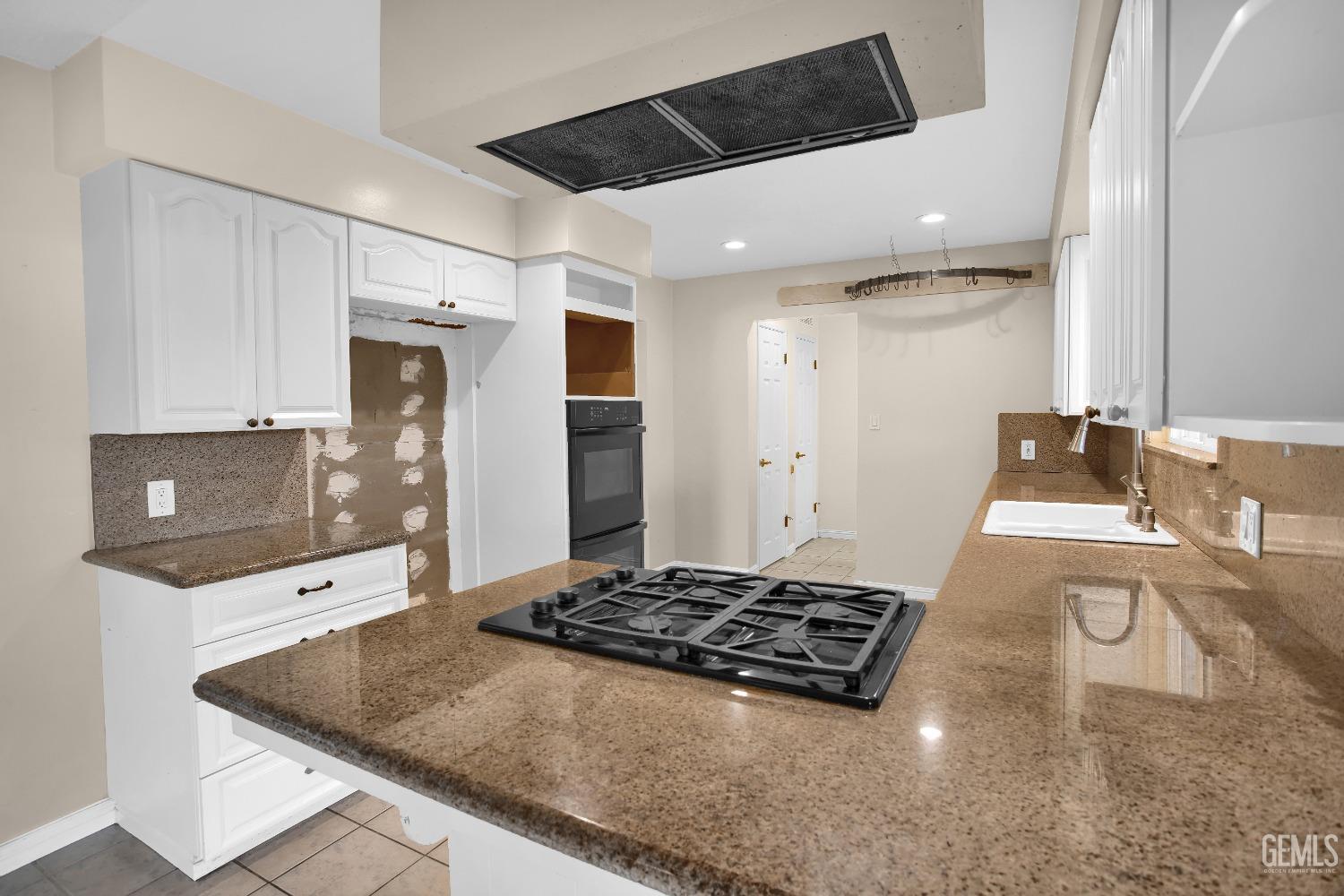 Undisclosed Address Bakersfield, CA 93312 - Photo 7 of 26 a living room with stainless steel appliances kitchen island granite countertop a stove and a sink