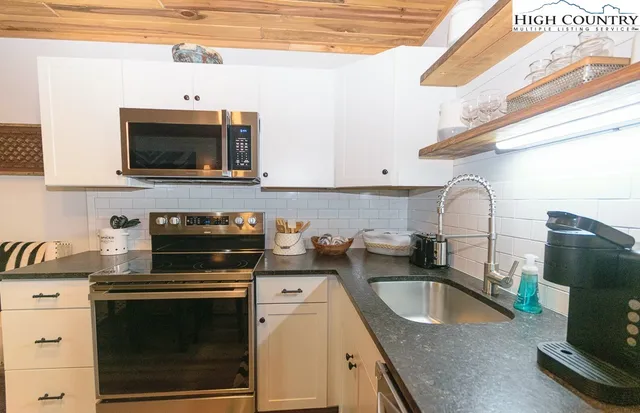 a kitchen with granite countertop a sink a stove and cabinets