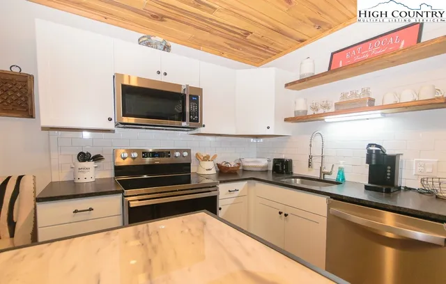 a kitchen with stainless steel appliances a stove sink and cabinets